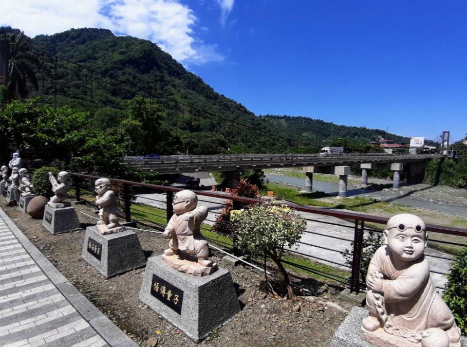 觸口龍隱寺前童子雕塑頗具童趣，周邊山景秀麗。