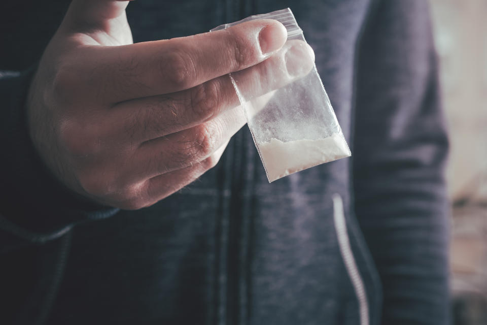 Midsection Of Man Holding Cocaine