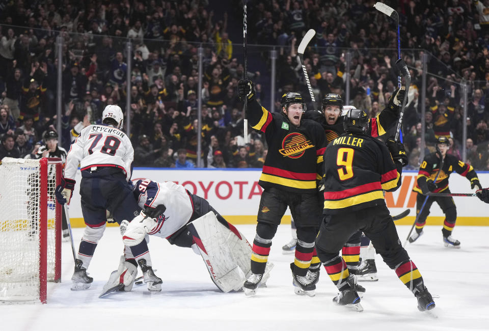 Vancouver Canucks' Brock Boeser, Pius Suter, back right, and J.T. Miller (9) celebrate Boeser's third goal against Columbus Blue Jackets goalie Elvis Merzlikins (90), during the third period of an NHL hockey game Saturday, Jan. 27, 2024, in Vancouver, British Columbia.(Darryl Dyck/The Canadian Press via AP)