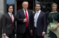 In this June 19, 2013 photo, Donald Trump, center, gives the thumbs up as he arrives with son Donald Trump Jr., daughter Ivanka Trump and Joo Kim Tiah, CEO and president of Holborn Group, to announce the building of Trump International Hotel and Tower Vancouver in downtown Vancouver, British Columbia, Canada. The 69-story tower has drawn praise for its sleek, twisting design. Prices for the condominiums have set records. But the politics of President Donald Trump have caused such outrage that the mayor won’t attend the Feb. 28 grand opening and has lobbied for a name change. (Jonathan Hayward/The Canadian Press via AP)