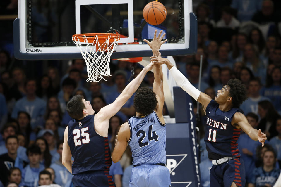 Villanova's Jeremiah Robinson-Earl (24) shoots between Pennsylvania's AJ Brodeur (25) and Lucas Monroe (11) during the first half of an NCAA college basketball game Wednesday, Dec. 4, 2019, in Villanova, Pa. (AP Photo/Matt Slocum)