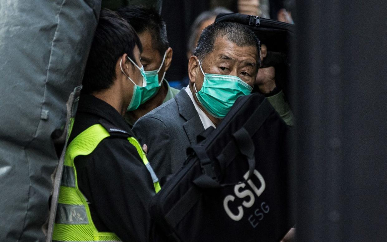 Jimmy Lai (R) being escorted into a Hong Kong Correctional Services van - AFP