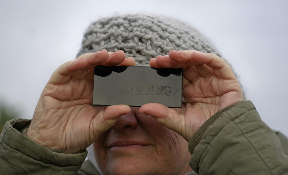 A woman looks through a special glass during a solar eclipse, partially seen in Montevideo, Uruguay, Tuesday, July 2, 2019. A solar eclipse occurs when the moon passes between the Earth and the sun and scores a bull’s-eye by completely blocking out the sunlight. (AP Photo/Matilde Campodonico)