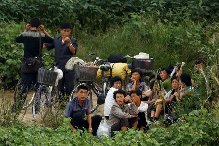 People wait for a boat at the bank of the Yalu River, outside the North Korean town of Sinuiju, opposite Dandong in China's Liaoning province, September 11, 2016. REUTERS/Thomas Peter