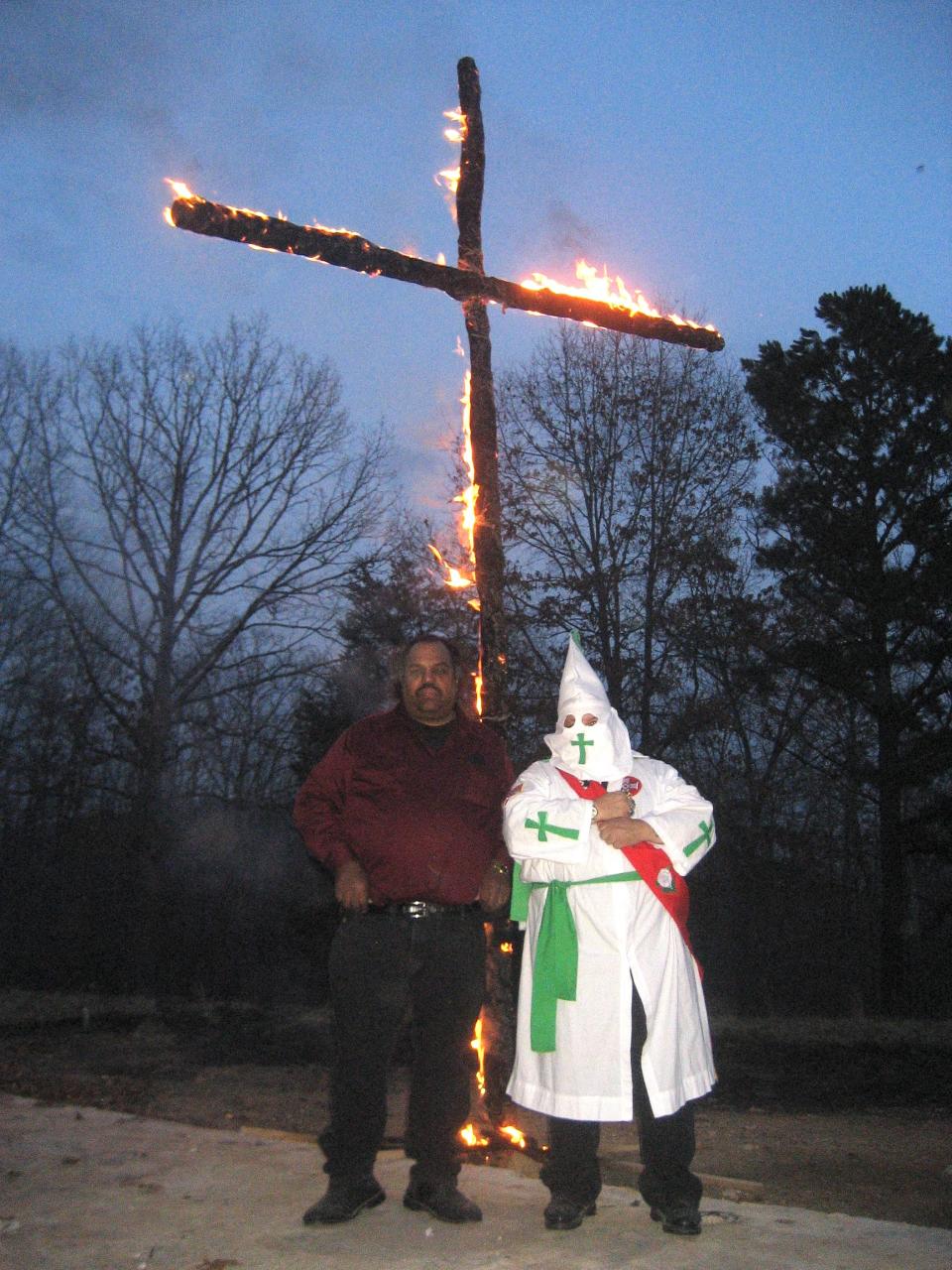 Daryl Davis and member of Ku Klux Klan in front of a burning cross