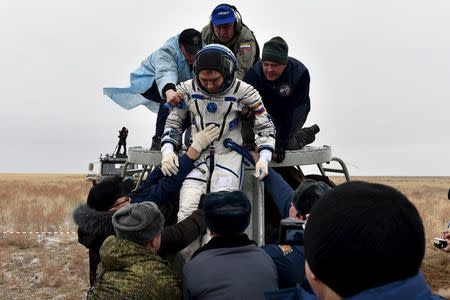 Ground personnel help Russian cosmonaut Sergei Volkov to get out of a Soyuz capsule shortly after landing near the town of Dzhezkazgan (Zhezkazgan), Kazakhstan, March 2, 2016. REUTERS/Kirill Kudryavtsev/Pool