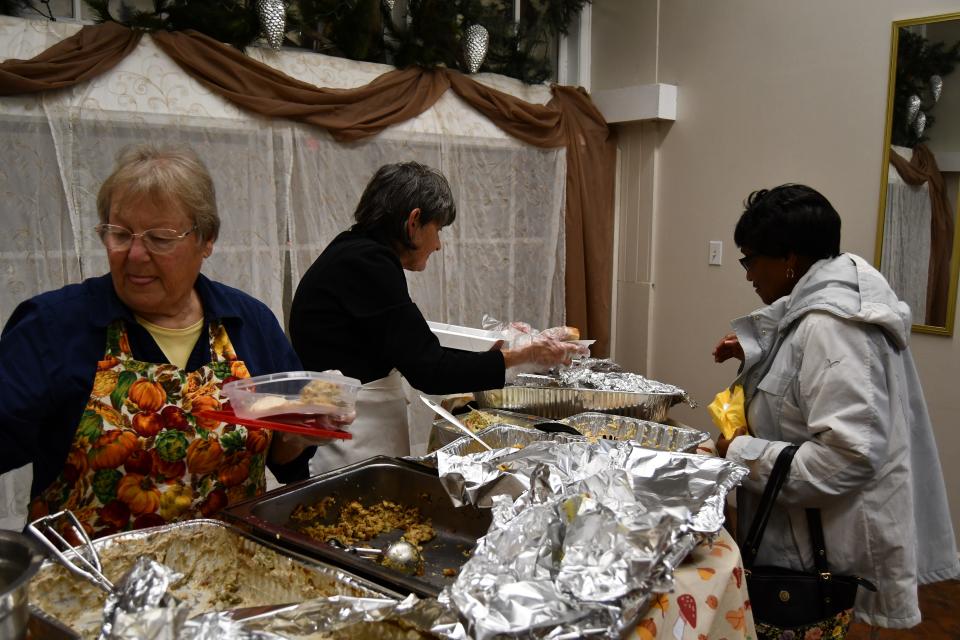 Several volunteers at the Pontifex hand out Thanksgiving dinners.