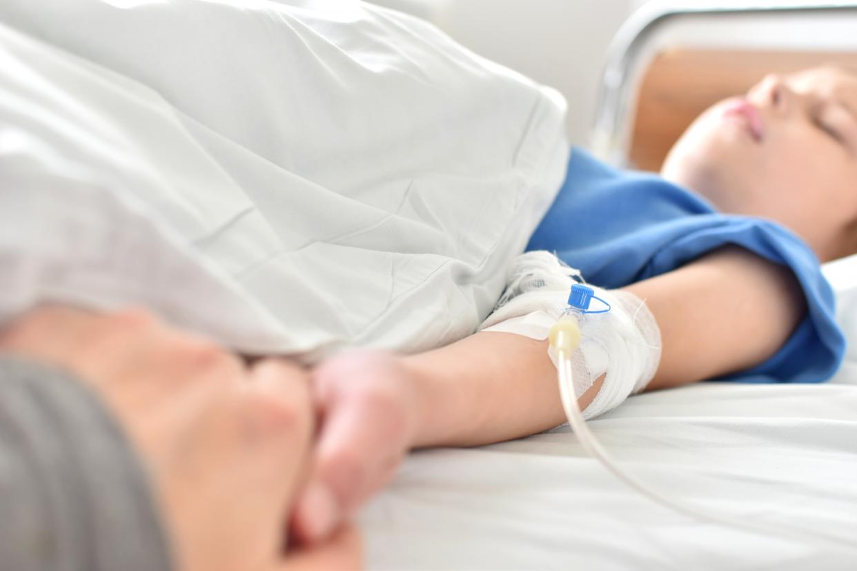 Cropped Image Of Parent Holding Daughter Hand Sleeping On Bed In Hospital