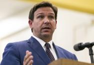 FILE - This May 4 2021 file photo shows Florida Gov. Ron DeSantis, center, speaks during a news conference at West Miami Middle School in Miami. Several states scaled back their reporting of COVID-19 statistics this July 2021, just as cases across the country started to skyrocket, depriving the public of real-time information on outbreaks, cases, hospitalizations and deaths in their communities. (Matias J. Ocner/Miami Herald via AP, File)