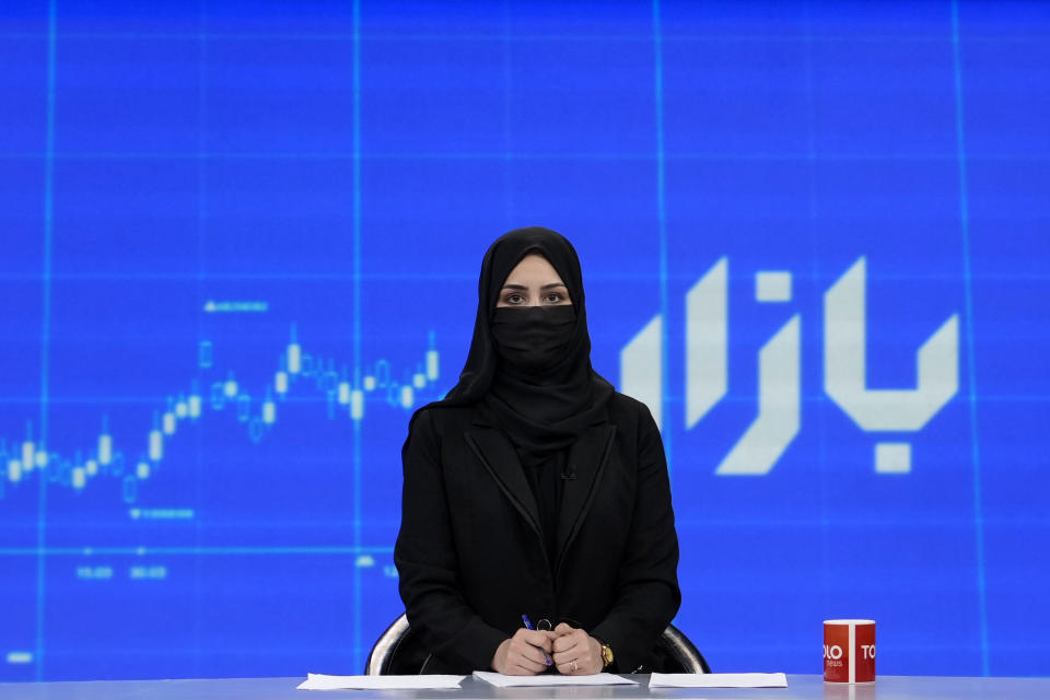 TV anchor Khatereh Ahmadi wears a face covering as she reads the news on TOLO NEWS, in Kabul, Afghanistan, Sunday, May 22, 2022. Afghanistan's Taliban rulers have begun enforcing an order requiring all female TV news anchors in the country to cover their faces while on-air. The move Sunday is part of a hard-line shift drawing condemnation from rights activists. (AP Photo/Ebrahim Noroozi)