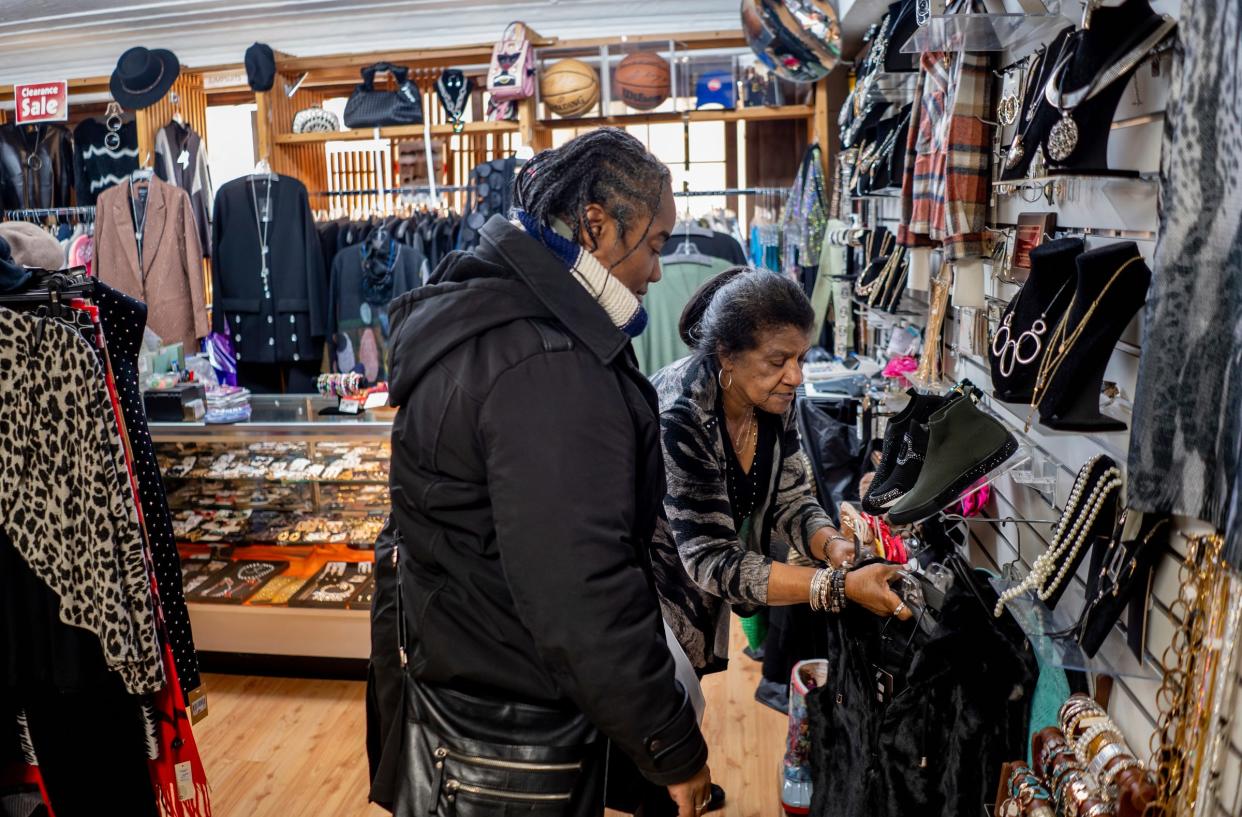 The Fashion Place co-owner Jean Jarrett, right, shows items to Maiysha Daniel-Smith of Detroit as she shops at her business that's been located in the same space for 41 years in the Fisher Building in Detroit on Wednesday, November 29, 2023.