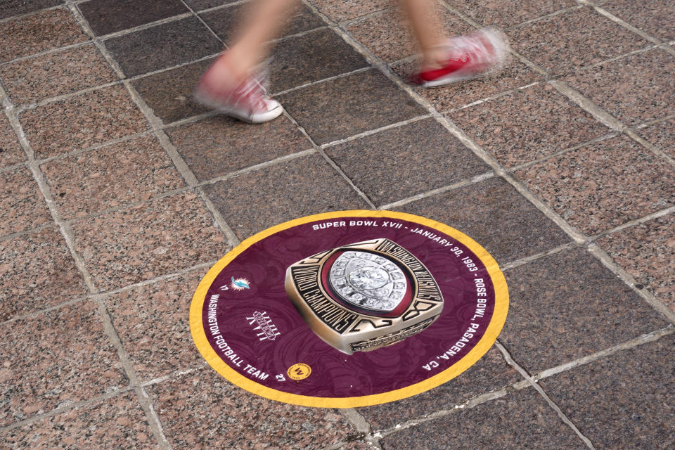 FILE - In this Feb. 5, 2021, file photo, a child walks past a marker for a past Super Bowl Champion as she walks along the Hillsborough River in Tampa, Fla. The city is hosting Sunday's Super Bowl 55 football game between the Tampa Bay Buccaneers and the Kansas City Chiefs. (AP Photo/Charlie Riedel, File)