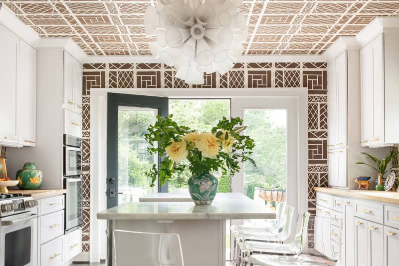 White and brown kitchen with patterned wallpaper on walls and ceiling