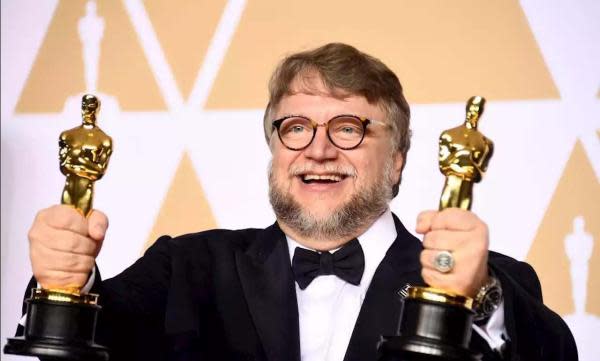 Guillermo del Toro sosteniendo dos Premios Óscar