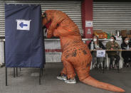 A person in a dinosaur suit votes during the second day of the Constitutional Convention election to select assembly members that will draft a new constitution, in Santiago, Chile, Sunday, May 16, 2021. (AP Photo/Esteban Felix)