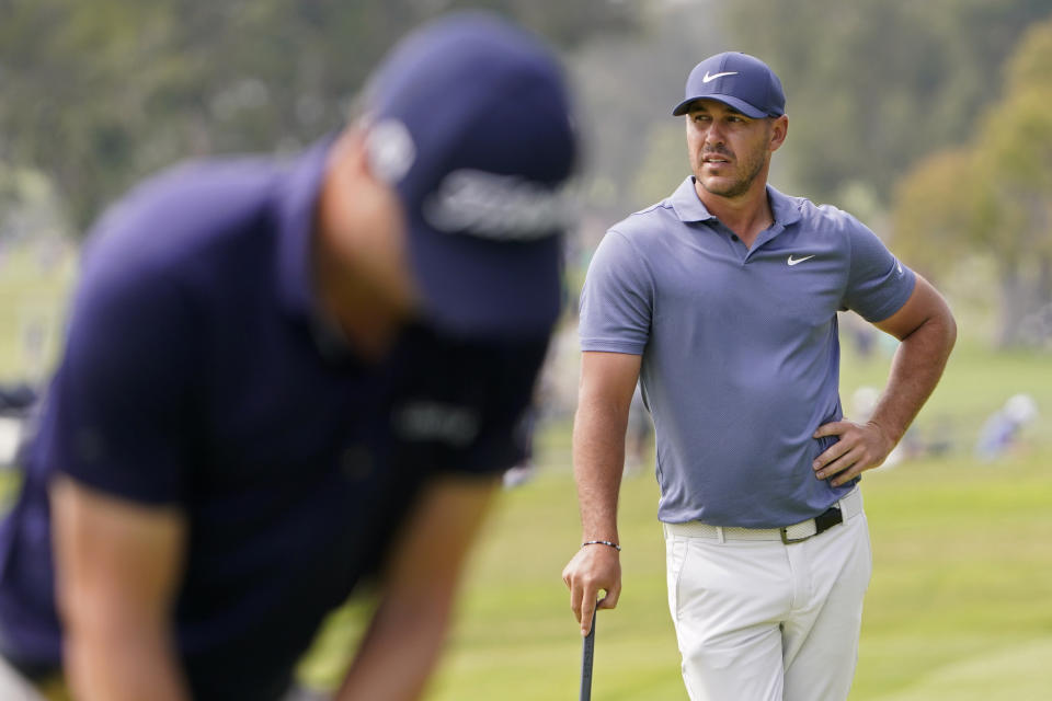 Brooks Koepka, right, waits to putt as Justin Thomas plays his shot on the 10th green during the second round of the U.S. Open Golf Championship, Friday, June 18, 2021, at Torrey Pines Golf Course in San Diego. (AP Photo/Jae C. Hong)