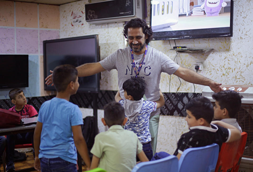 In this Wednesday, Oct. 17, 2018, Hisham al-Dahabi, center, a social worker and philanthropist visits with students at the orphanage he runs in the heart of Baghdad, Iraq. Prime Minister-designate Adel Abdul-Mahdi opened an online portal for anyone to apply to run Iraq’s 22 ministries and take over the posts that have come to be associated with patronage and graft. Al-Dahabi said he applied reluctantly to be the minister of labor and social affairs. (AP Photo/Hadi Mizban)