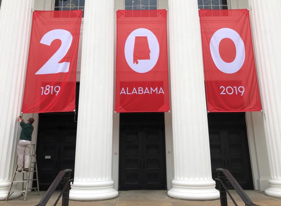 FILE - In this Feb. 28, 2019 file photo a worker adjusts a banner celebrating Alabama's bicentennial outside the Department of Archives and History in Montgomery, Ala. Leaders in Alabama are confronting the legacy of what might be the grandest Confederate memorial of all: the state's Department of Archives and History. During the current national reckoning over race, its current leaders acknowledged the department once played a role in systemic racism by promoting “lost cause” narrative of Civil War history that was favored by some whites and all but excluding Blacks. (AP Photo/Jay Reeves, File)