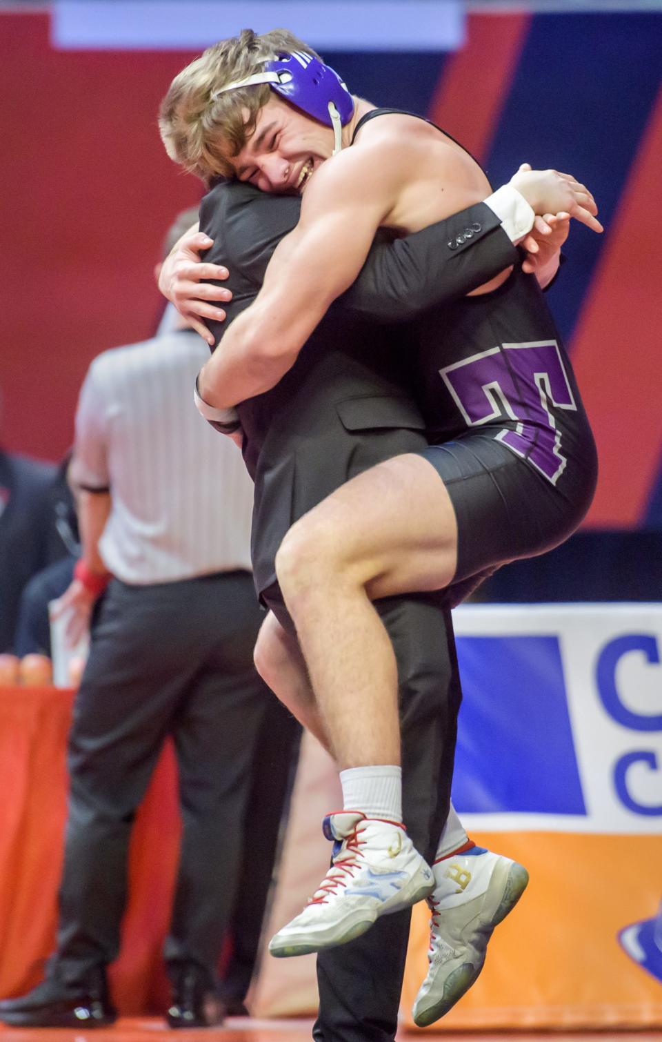 El Paso-Gridley's Dax Gentes hugs his coach after taking the title in the 160-pound match of the  Class 1A state wrestling tournament Saturday, Feb. 18, 2023 at State Farm Arena in Champaign. 