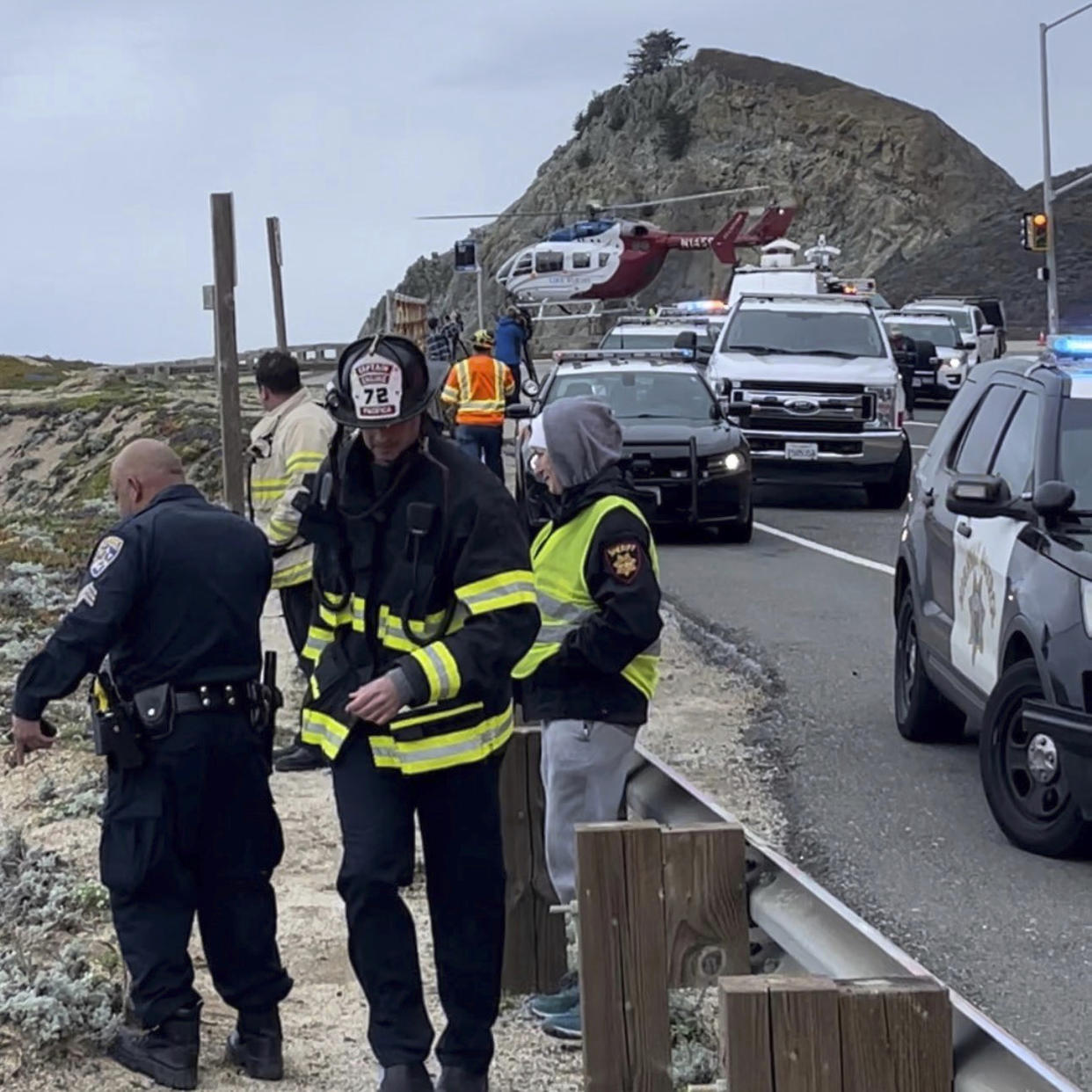 Emergency personnel respond after a Tesla plunged off a Northern California cliff along the Pacific Coast Highway, Monday, Jan. 2, 2023, near an area known as Devil's Slide, leaving four people in critical condition. (San Mateo County Sheriff's Office via AP)