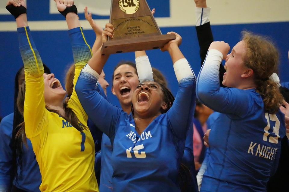 McCallum's Saraih Taylor, middle, and teammates celebrate winning the District 24-5A Crown with the Knights' 3-0 win ove Ann Richards on Tuesday at McCallum High School.