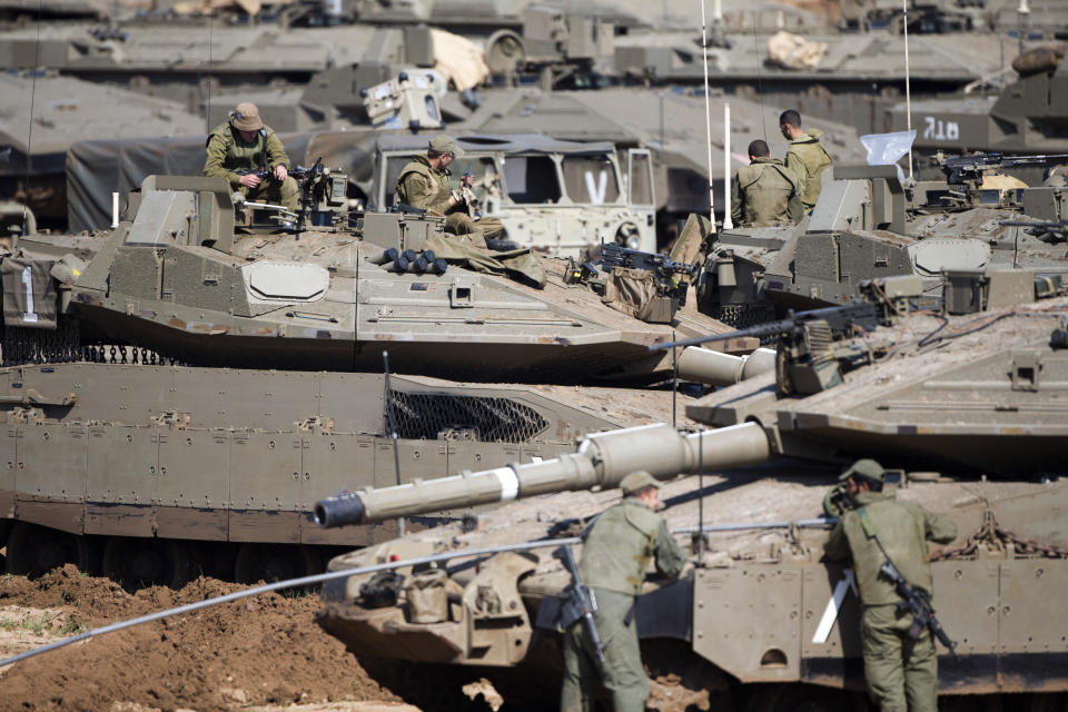 Israeli soldiers work on their tanks at a gathering area near the Israel-Gaza border, in southern Israel, Tuesday, March 26, 2019. Israeli Prime Minister Benjamin Netanyahu returned home from Washington on Tuesday, heading straight into military consultations after a night of heavy fire as Israeli aircraft bombed Gaza targets and the strip's militants fired rockets into Israel. (AP Photo/Ariel Schalit)
