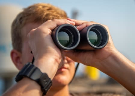 U.S. Navy sailor scans the horizon during his watch aboard the USS Bainbridge in the Arabian Gulf