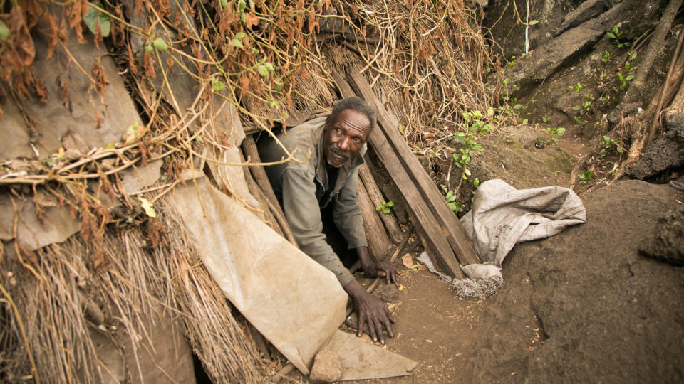 A man crawls out of the cave he has inhabited for decades in Kenya's Great Rift Valley. Several hundred people live in caves within the Utut Forest. (Photo: Zoe Flood)