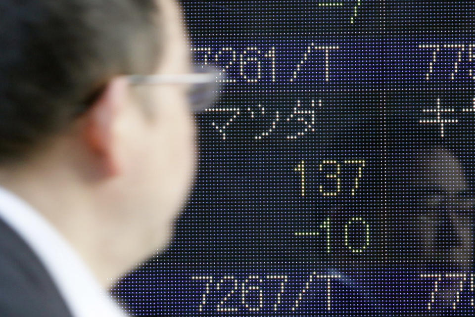 A man glances at an electronic stock board indicating the share price of Japanese car maker Mazda that lost 10 yen to 137 in Tokyo Thursday, Feb. 23, 2012. Mazda stock dived nearly 7 percent Thursday after the struggling car maker said it will raise about $2 billion from selling new shares to invest in assembly plants and developing new vehicle technologies. (AP Photo/Koji Sasahara)