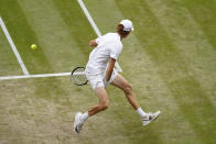 Italy's Jannik Sinner plays a return from between his legs to Serbia's Novak Djokovic in a men's singles quarterfinal match on day nine of the Wimbledon tennis championships in London, Tuesday, July 5, 2022. (AP Photo/Alberto Pezzali)