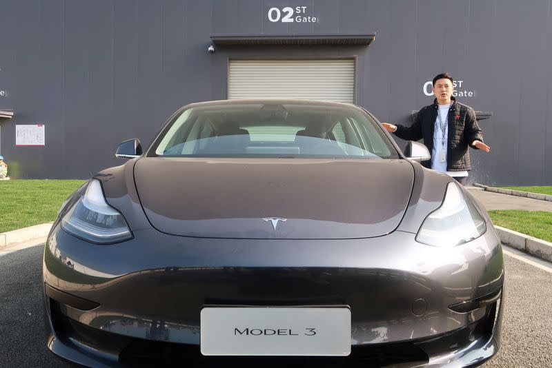 Staff member explains the China-made Tesla Model 3 vehicle at the Shanghai Gigafactory of the U.S. electric car maker in Shanghai