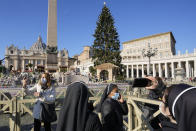 A nun takes photos of the nativity scene and Christmas tree in St. Peter's Square, at the Vatican, Friday, Dec. 17, 2021. Pope Francis is celebrating his 85th birthday Friday, a milestone made even more remarkable given the coronavirus pandemic, his summertime intestinal surgery and the weight of history: His predecessor retired at this age and the last pope to have lived any longer was Leo XIII over a century ago. (AP Photo/Andrew Medichini)