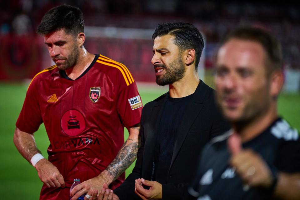 Aug 31, 2022; Chandler, Arizona, USA; Phoenix Rising manager Juan Guerra walks off the field at halftime while talking to midfielder Aodhan Quinn (14) with his team at Phoenix Rising FC Stadium. Mandatory Credit: Alex Gould/The Republic