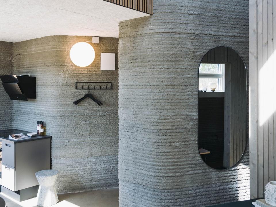 The walls of the 3D printed home with furniture like lights and a mirror.