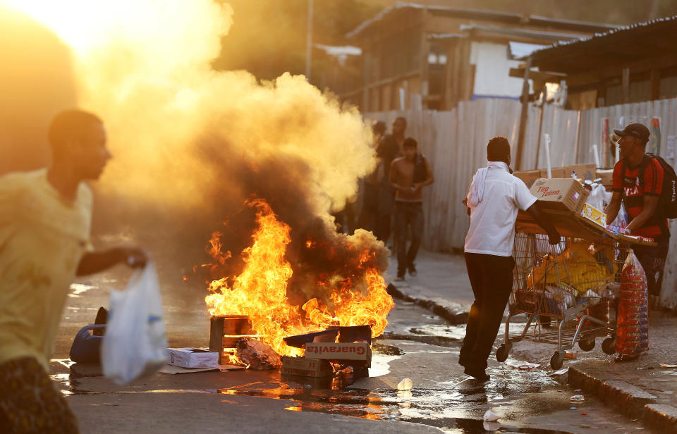 Demonstrators set fire to garbage outside of the central train station, during protest against the increase of bus fares in Rio de Janeiro, Brazil, Thursday, Feb. 6, 2014. Last year, millions of people took to the streets across Brazil complaining of higher bus fares, poor public services and corruption, while the country spent billions on the World Cup, which is scheduled to start in June.(AP Photo/Leo Correa)