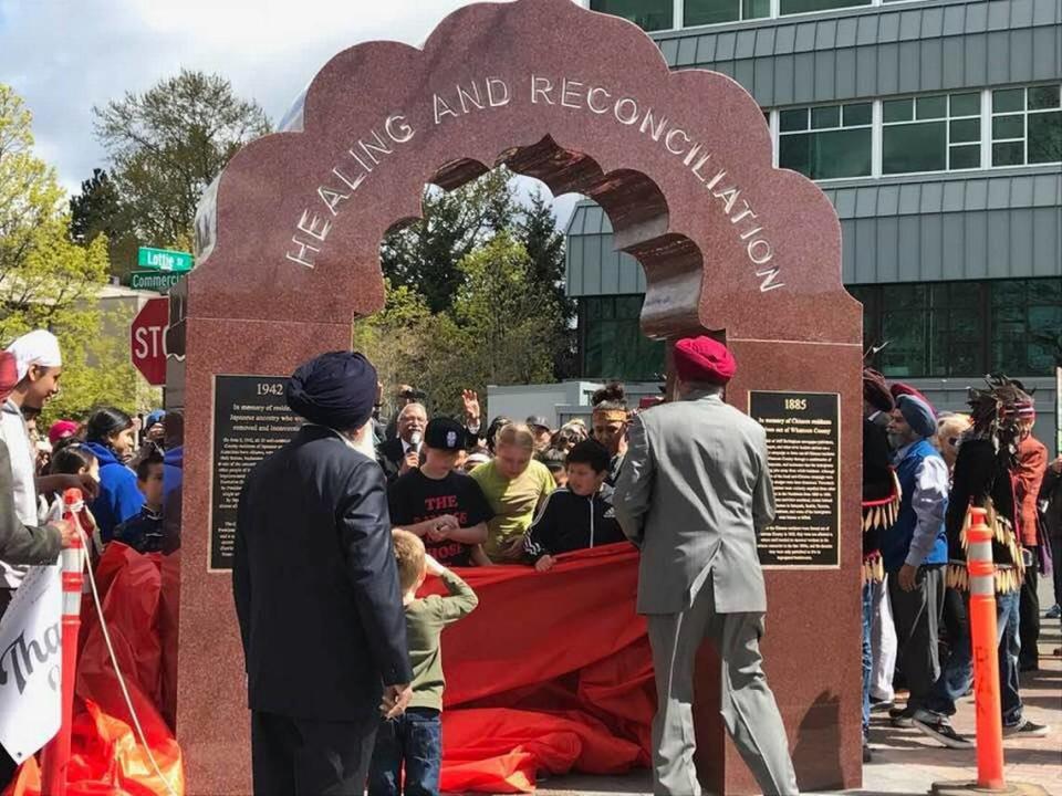 A celebration around The Arch of Healing and Reconciliation. The arch is a reminder of the past and bridge toward the future.