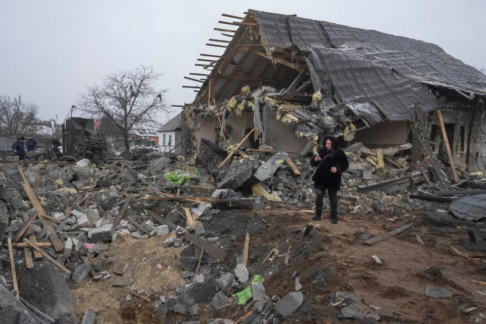 A local resident takes a photo of a missile crater and debris of a private house ruined in the Russian missile attack in Kyiv