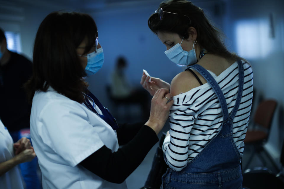 A nurse administrates a Pfizer/Biontech COVID-19 vaccine to a health care worker at the MontLegia CHC hospital in Liege, Belgium, Wednesday, Jan. 27, 2021. (AP Photo/Francisco Seco)