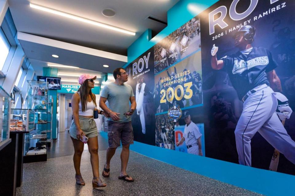 Jeff Campbell, 40, and Luana Fureando, 40, look at posters displayed within the Miami Marlins 30th Anniversary History Museum inside loanDepot park in the Little Havana neighborhood of Miami, Florida, on Wednesday, May 17, 2023.
