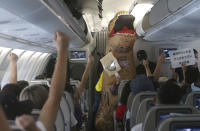 Participants vie to answer "first in the cabin" during a mock trip abroad at Taipei Songshan Airport in Taipei, Taiwan, Tuesday, July 7, 2020. Dozens of would-be travelers acted as passengers in an activity organized by Taiwan’s Civil Aviation Administration to raise awareness of procedures to follow when passing through customs and boarding their plane at Taipei International Airport. (AP Photo/Chiang Ying-ying)