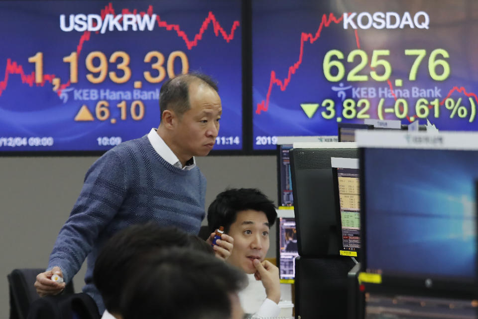 Currency traders watch monitors at the foreign exchange dealing room of the KEB Hana Bank headquarters in Seoul, South Korea, Wednesday, Dec. 4, 2019. Asian stock markets followed Wall Street lower after President Donald Trump cast doubt over the potential for a trade deal with China this year. (AP Photo/Ahn Young-joon)