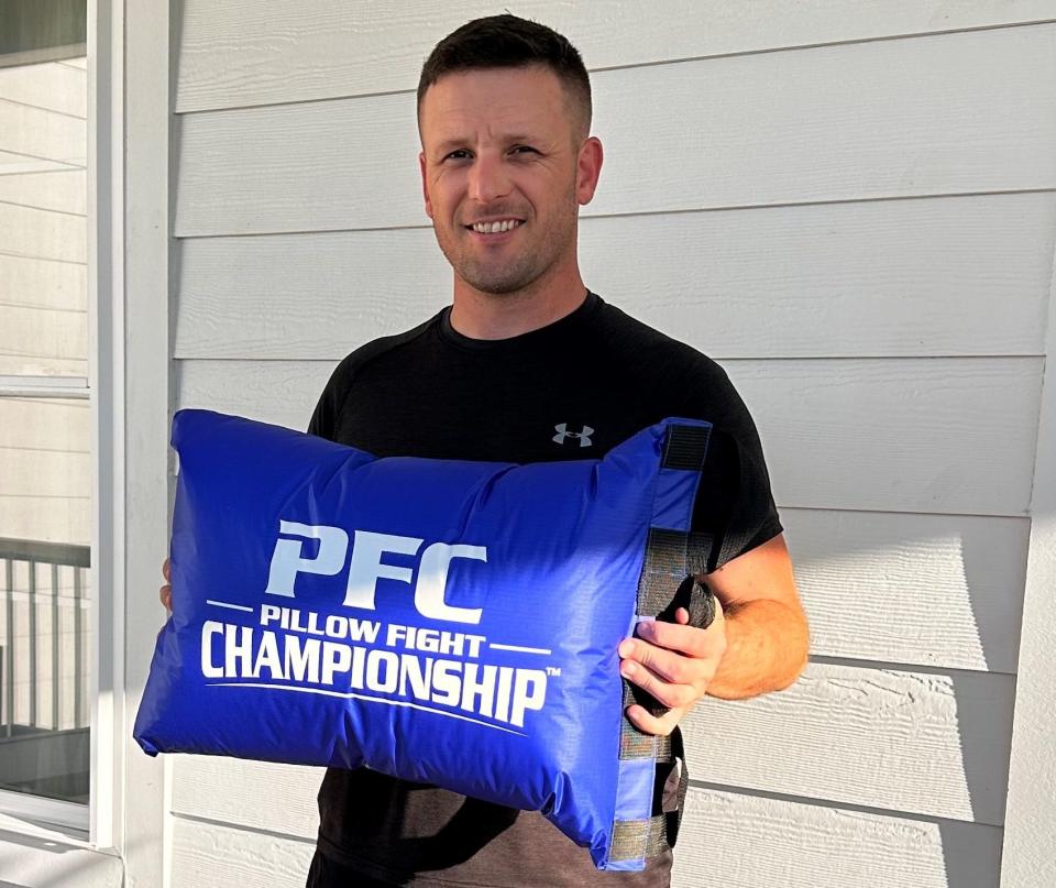 Clint Avalon, who will serve as referee for the Dickson Pillow Fights, holds an official Pillow Fight Championship pillow.
