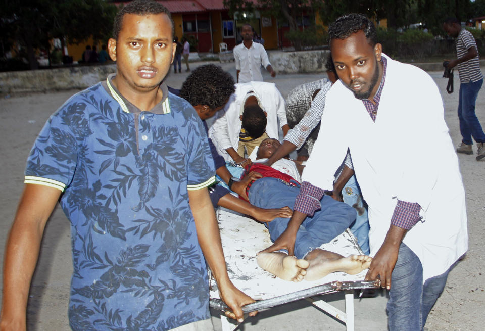 Medical workers help civilian on stretcher who was wounded in suicide bomb, at Madina hospital, Mogadishu, Wednesday, July 24, 2019. A suicide bomber walked into the office of Mogadishu's mayor and detonated explosives strapped to his waist, killing several people and badly wounding the mayor, Somali police said Wednesday. (AP Photo/Farah Abdi Warsameh)