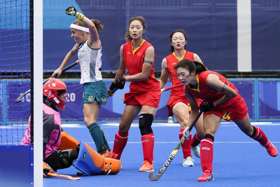 Australia's Emily Chalker, second from left, reacts after scoring on China goalkeeper Dongxiao Li, left, during a women's field hockey match at the 2020 Summer Olympics, Monday, July 26, 2021, in Tokyo, Japan. (AP Photo/John Minchillo)