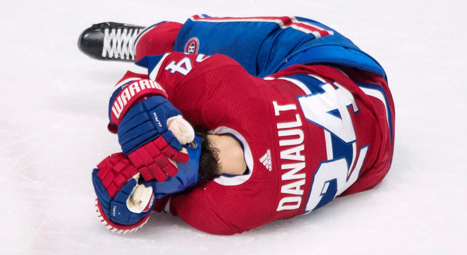 Canadiens’ Phillip Danault clutches his head after getting hit by a Zdeno Chara slap shot. (Graham Hughes/CP)