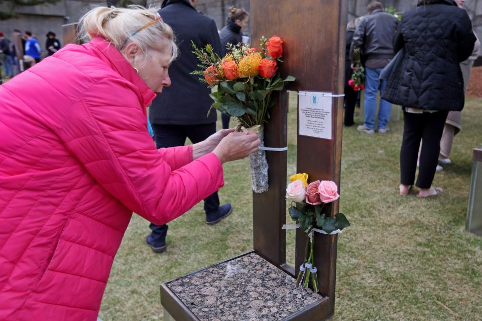 Charlene Jones places flowers on the chair of her sister, Judy J. Froh Fisher, on Friday during the 29th annual Remembrance Ceremony at the Oklahoma City National Memorial & Museum.