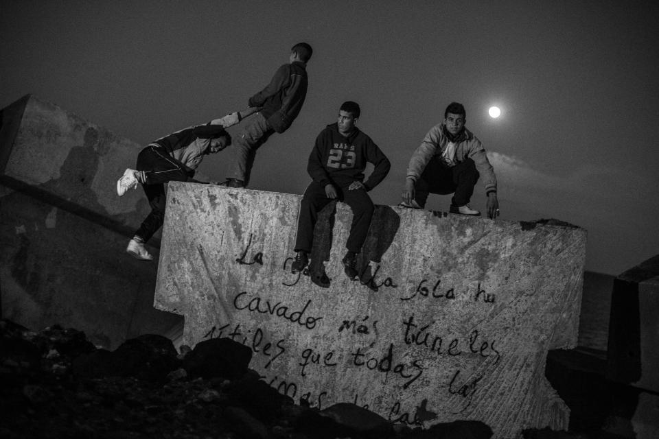 Moroccan kids sit on the breakwater next to Melilla´s harbor in 2014. (Photo: José Colón/MeMo for Yahoo News)