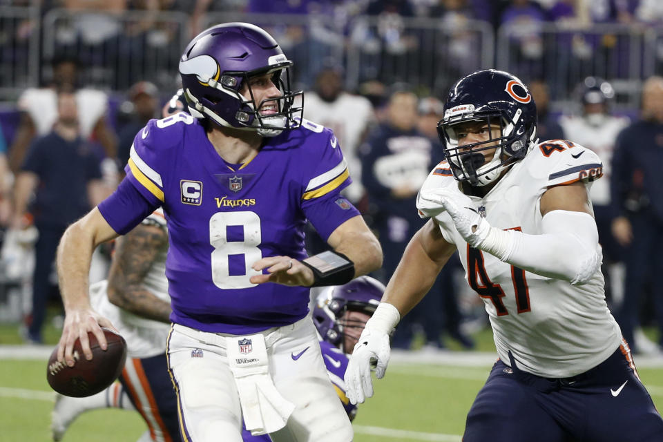 FILE - In this Dec. 30, 2018, file photo, Minnesota Vikings quarterback Kirk Cousins runs from Chicago Bears linebacker Isaiah Irving, right, during the second half of an NFL football game, in Minneapolis. Once again, Minnesota's biggest need in the draft is up front. The Vikings have used a first-round pick on an offensive lineman only once, in 2012, in the last 16 years, but they're due for an upgrade next week. (AP Photo/Bruce Kluckhohn, File)