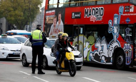 FILE PHOTO: A police traffic officer watches motorists entering the center on the first day of a city ordinance to ban certain vehicles without the proper sticker according to their emissions in Madrid, Spain, November 30, 2018.  REUTERS/Paul Hanna