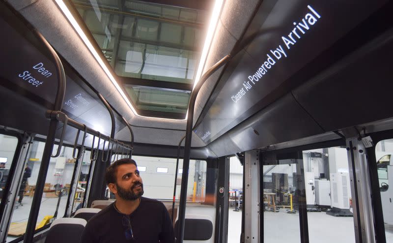 Avinash Rugoobur, president of electric van and bus maker Arrival, shows off the startup's pre-production electric bus model at the company's research and development centre in Banbury